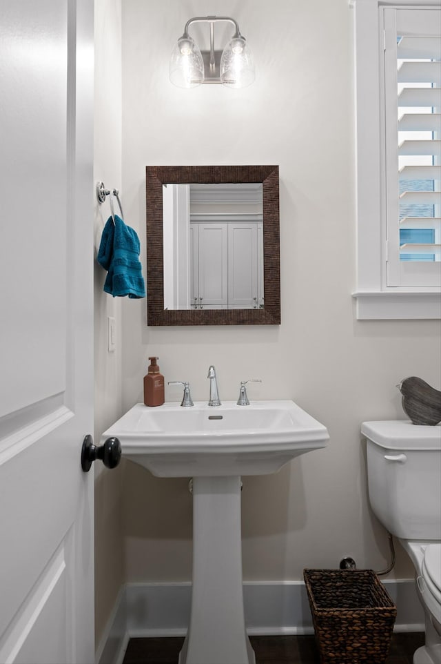 bathroom with toilet and baseboards