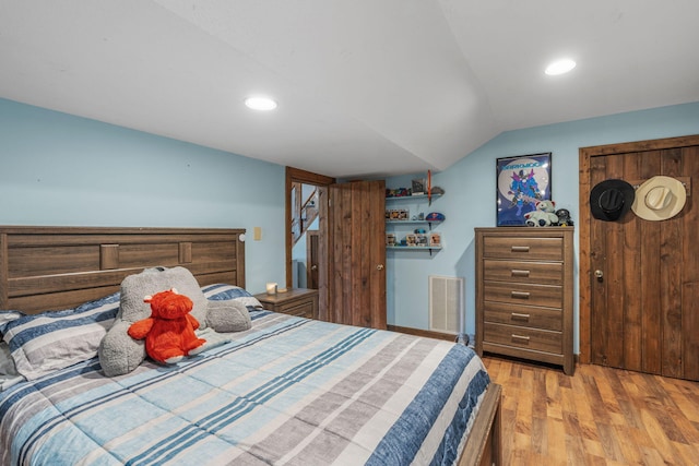 bedroom featuring light hardwood / wood-style flooring and vaulted ceiling