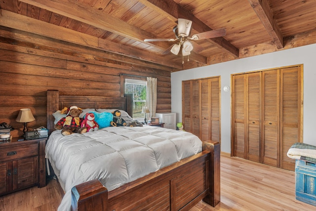 bedroom featuring beam ceiling, rustic walls, ceiling fan, and wood ceiling