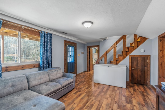 living room with a textured ceiling and dark hardwood / wood-style floors