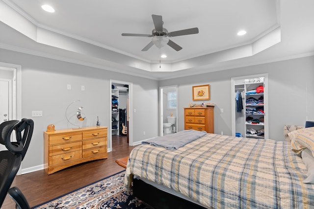 bedroom featuring a spacious closet, a raised ceiling, and a closet
