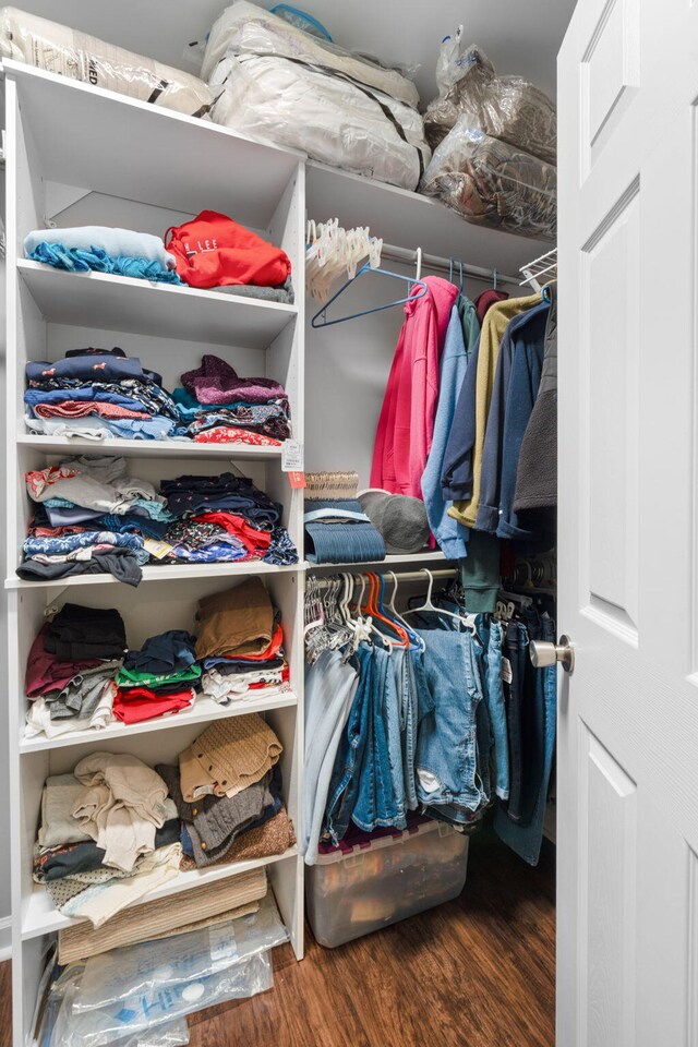 walk in closet with wood finished floors
