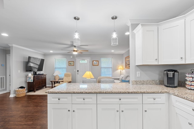 kitchen featuring white cabinets, a peninsula, dark wood-style floors, ceiling fan, and crown molding