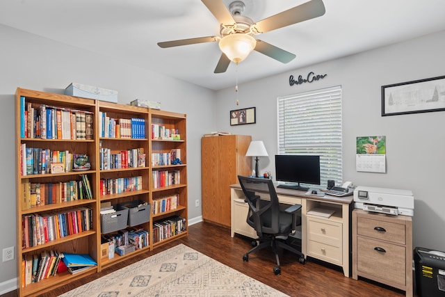 office area featuring baseboards, ceiling fan, and dark wood finished floors