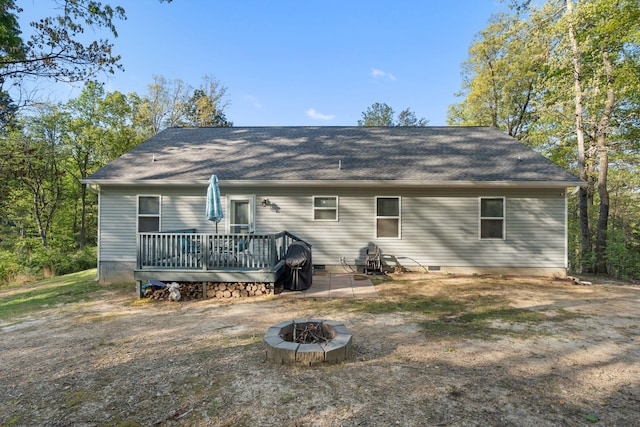 rear view of house with a fire pit, a wooden deck, and crawl space