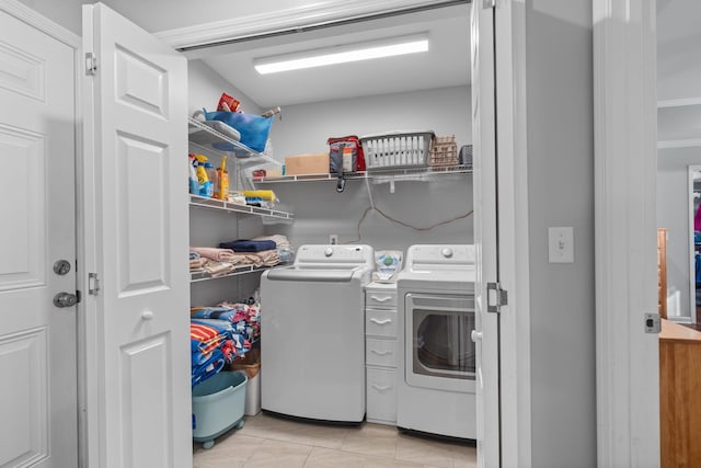 laundry area with washer and clothes dryer, laundry area, and light tile patterned flooring