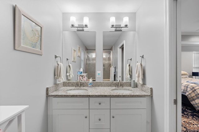 ensuite bathroom with double vanity, a shower stall, ensuite bathroom, and a sink