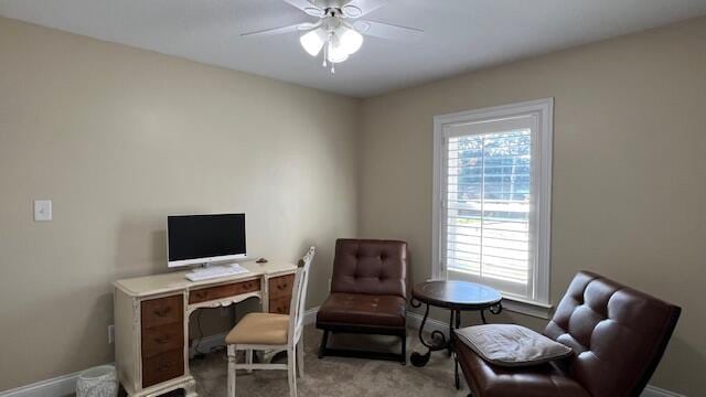 office space featuring light carpet, baseboards, and ceiling fan