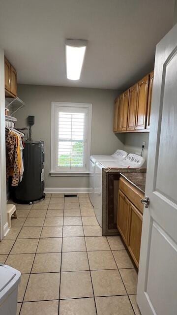 washroom with cabinet space, water heater, light tile patterned floors, and washing machine and clothes dryer