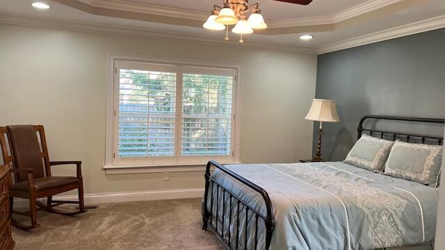 carpeted bedroom featuring ornamental molding, baseboards, recessed lighting, and a raised ceiling