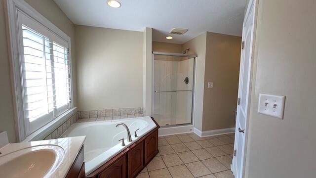 full bath featuring a stall shower, a wealth of natural light, tile patterned flooring, and a garden tub