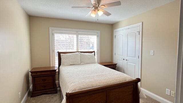 carpeted bedroom featuring ceiling fan, baseboards, and a closet