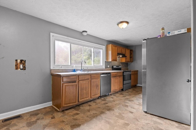608 Parkview Dr, Chattanooga, TN 37411 - kitchen featuring appliances with stainless steel finishes, baseboards, under cabinet range hood, a sink, and brown cabinetry