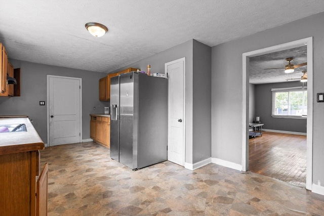 608 Parkview Dr, Chattanooga, TN 37411 - kitchen featuring stainless steel refrigerator with ice dispenser, a textured ceiling, stone finish flooring, ceiling fan, and brown cabinets