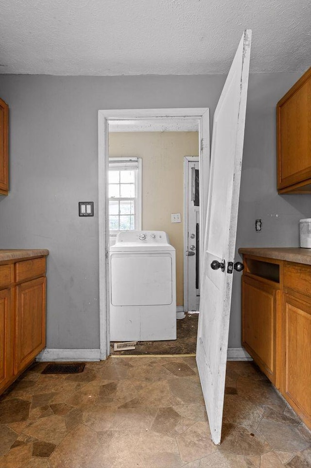 608 Parkview Dr, Chattanooga, TN 37411 - laundry area featuring washer / dryer, stone finish floors, a textured ceiling, baseboards, and cabinet space