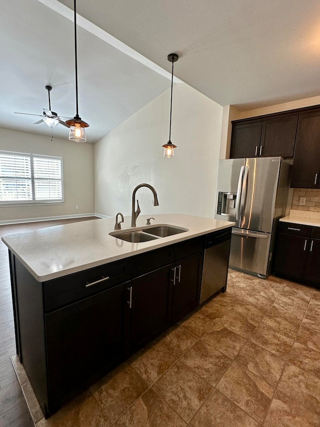 kitchen featuring ceiling fan, sink, hanging light fixtures, a kitchen island with sink, and appliances with stainless steel finishes