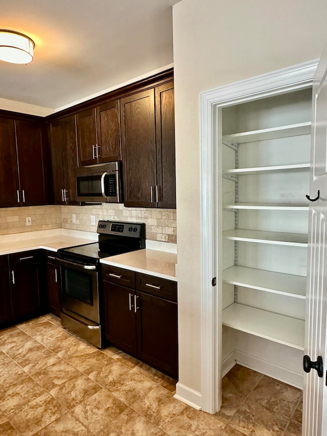 kitchen featuring appliances with stainless steel finishes, tasteful backsplash, and dark brown cabinets