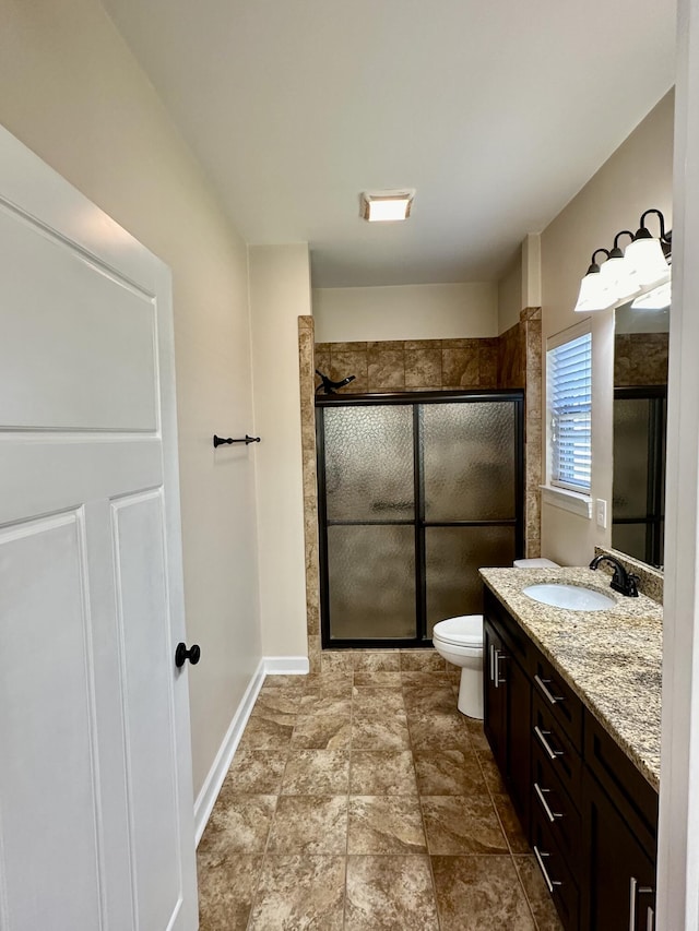 bathroom with vanity, toilet, and a shower with door