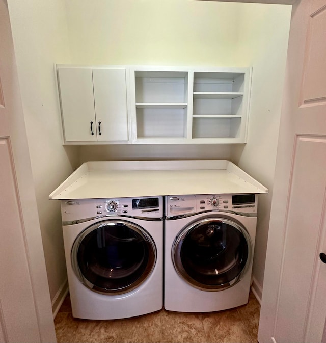 laundry room with washer and clothes dryer, cabinets, and light tile patterned floors