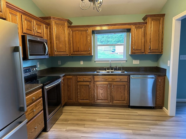 740 Grassy Branch Rd, Dayton, TN 37321 - kitchen with appliances with stainless steel finishes, dark countertops, light wood-style flooring, brown cabinetry, and vaulted ceiling