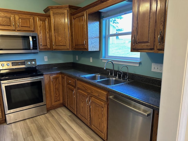 740 Grassy Branch Rd, Dayton, TN 37321 - kitchen with stainless steel appliances, dark countertops, light wood-style flooring, and brown cabinetry