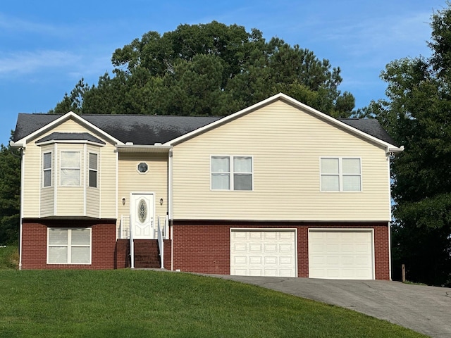 740 Grassy Branch Rd, Dayton, TN 37321 - split foyer home featuring a garage, asphalt driveway, brick siding, and a front yard