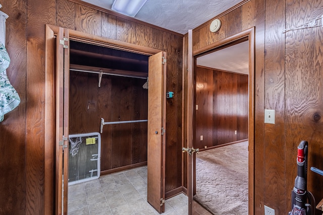 hallway featuring wood walls