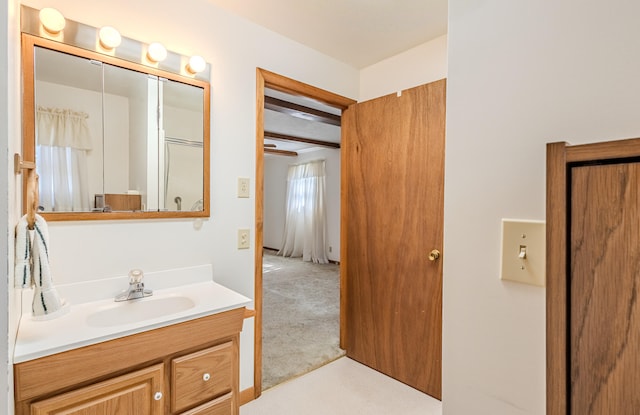 bathroom with beamed ceiling and vanity