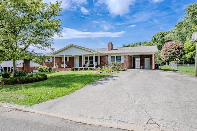 ranch-style house featuring a carport, covered porch, and a front yard