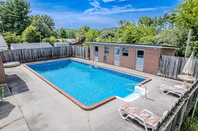 view of pool featuring an outbuilding and a patio