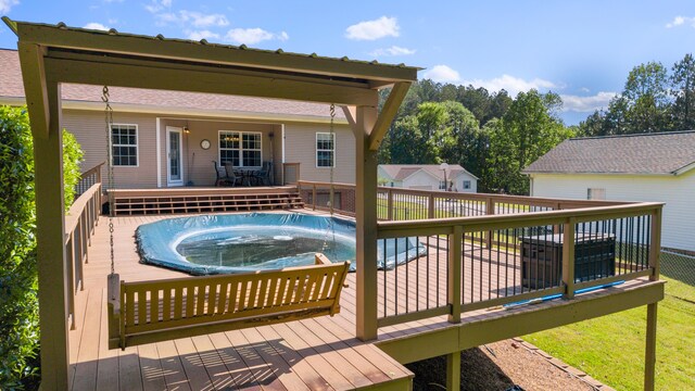 view of swimming pool featuring a jacuzzi and a deck