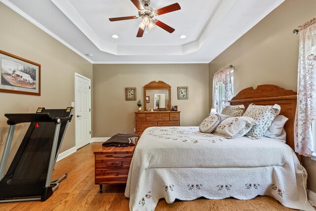 bedroom with baseboards, recessed lighting, wood finished floors, ceiling fan, and a raised ceiling