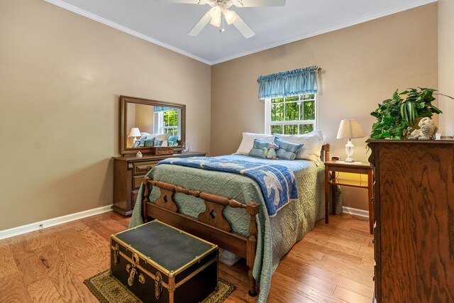 bedroom with a ceiling fan, baseboards, crown molding, and light wood finished floors