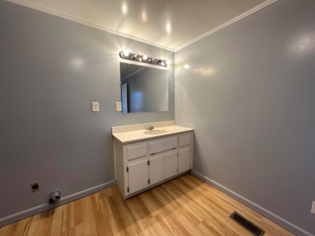 bathroom with vanity, wood-type flooring, and ornamental molding