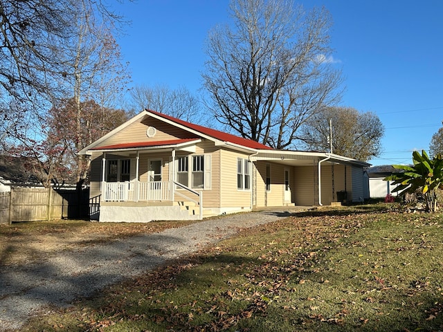 view of front facade featuring a carport, covered porch, and a front lawn