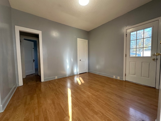 interior space featuring a textured ceiling and light hardwood / wood-style flooring