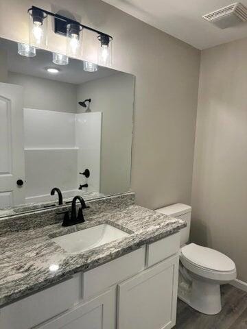 bathroom with vanity, wood-type flooring, and toilet