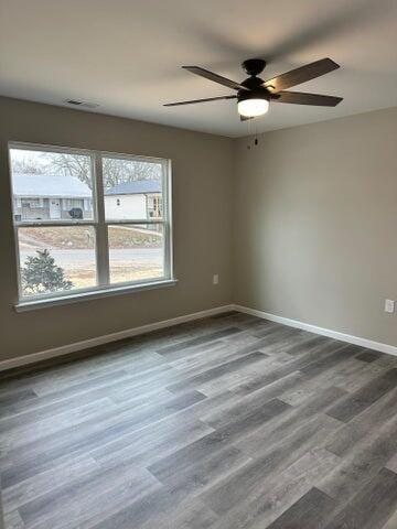 spare room with hardwood / wood-style floors, plenty of natural light, and ceiling fan