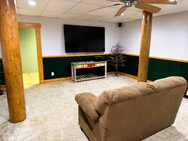 living room with carpet floors, ceiling fan, and a paneled ceiling