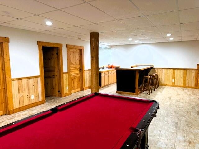 rec room featuring a paneled ceiling, wooden walls, pool table, and light hardwood / wood-style flooring