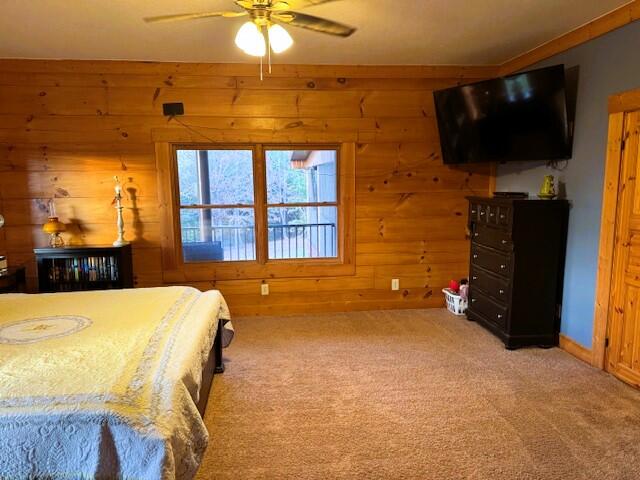 bedroom with wooden walls and carpet floors