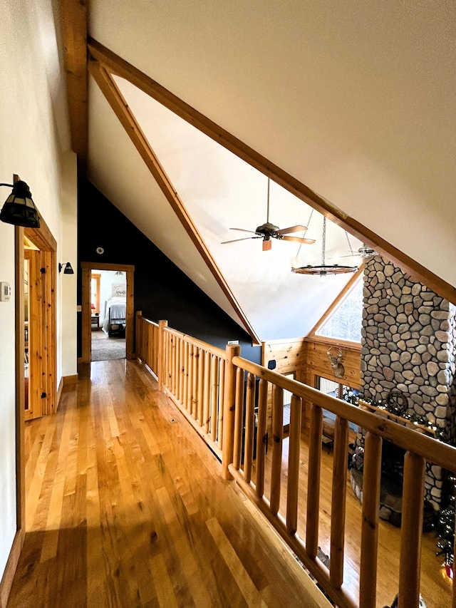 hall featuring wood-type flooring, high vaulted ceiling, and wood walls