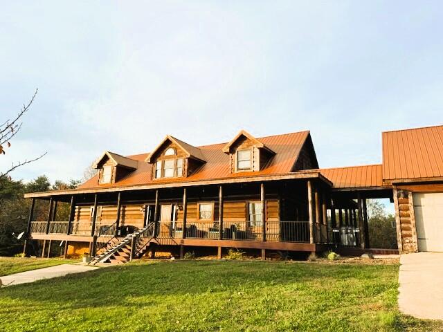 view of front of home with a front lawn, covered porch, and a garage