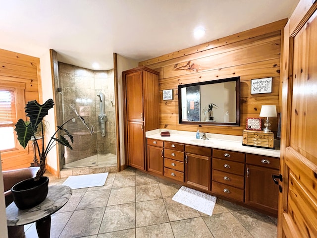 bathroom featuring tile patterned floors, vanity, a shower with door, and wooden walls