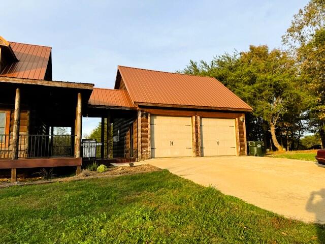 view of front of home featuring a porch, a front yard, and a garage