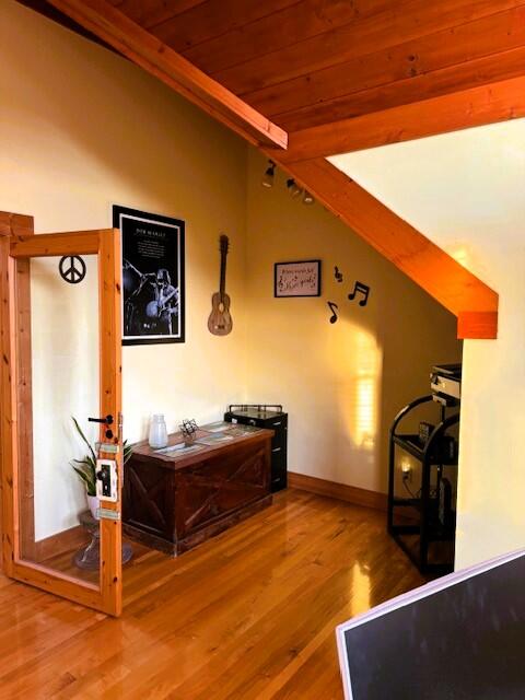 interior space with beamed ceiling, hardwood / wood-style flooring, and wood ceiling