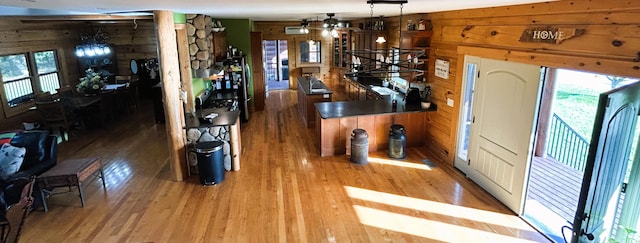 entryway with hardwood / wood-style floors, ceiling fan, and wood walls