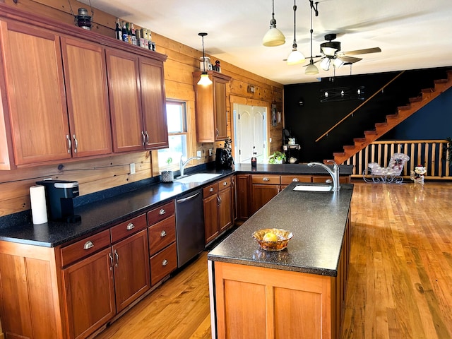 kitchen with dishwasher, light wood-type flooring, sink, and wooden walls