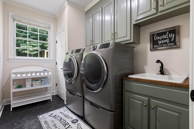 washroom featuring cabinets, sink, crown molding, washer and dryer, and dark tile patterned floors