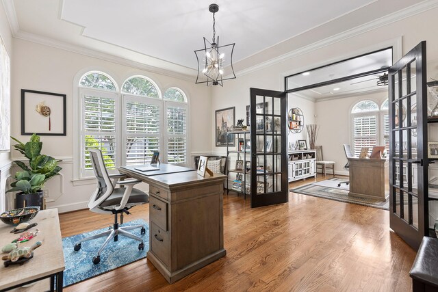 office area with a notable chandelier, wood-type flooring, and ornamental molding